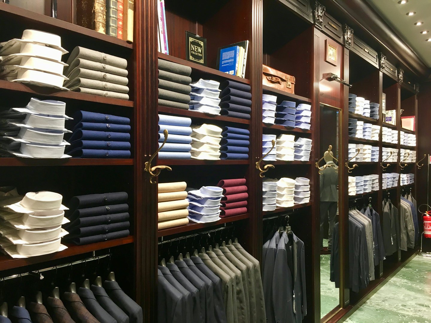 Neatly arranged men's formal wear on store shelves and racks.